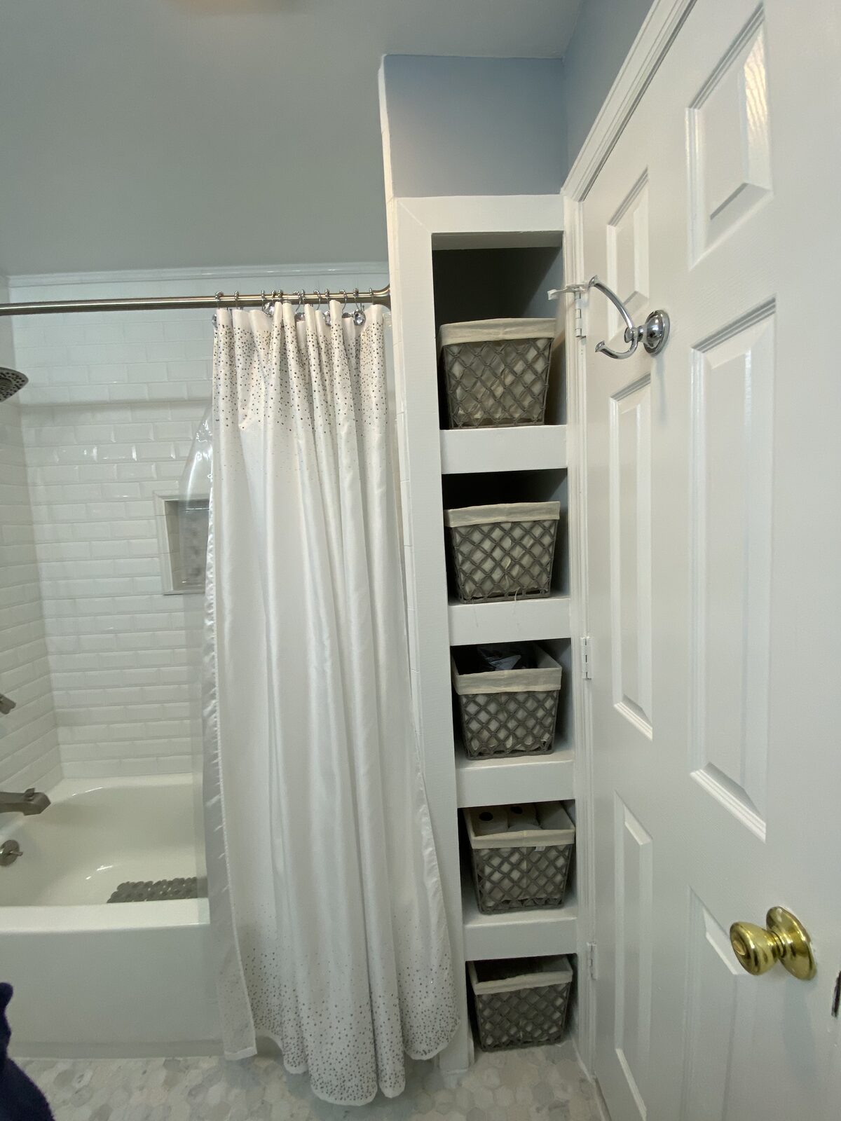 Bathroom with built-in shelving niche